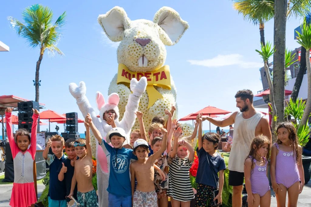 Giant Easter Bunny installation at KU DE TA Bali, celebrating Easter with family friendly activities including egg hunts, kids games, art and craft, and face painting by the beach.